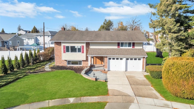 raised ranch featuring a front yard and a garage