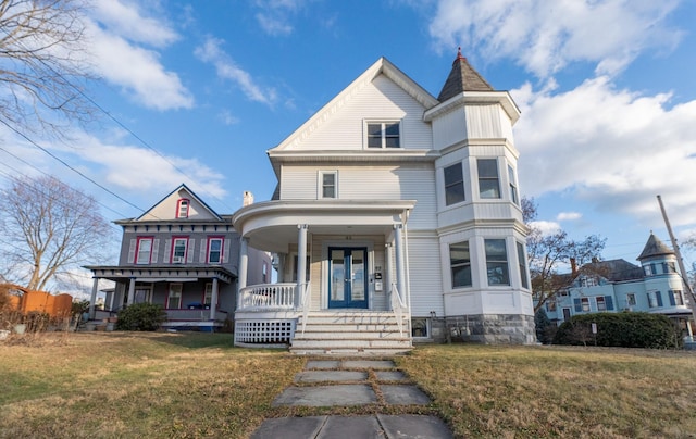 victorian-style house with a porch and a front yard