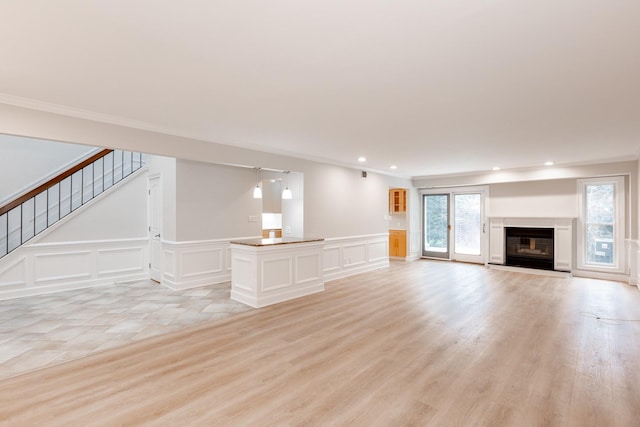 unfurnished living room with light tile patterned floors and ornamental molding