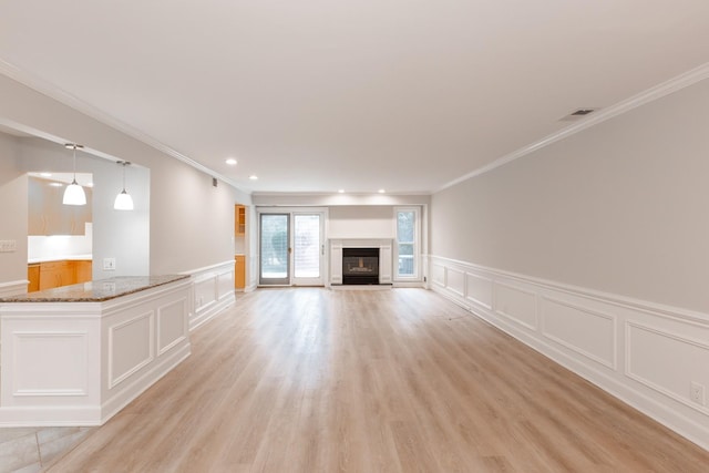 unfurnished living room with light wood-type flooring and ornamental molding