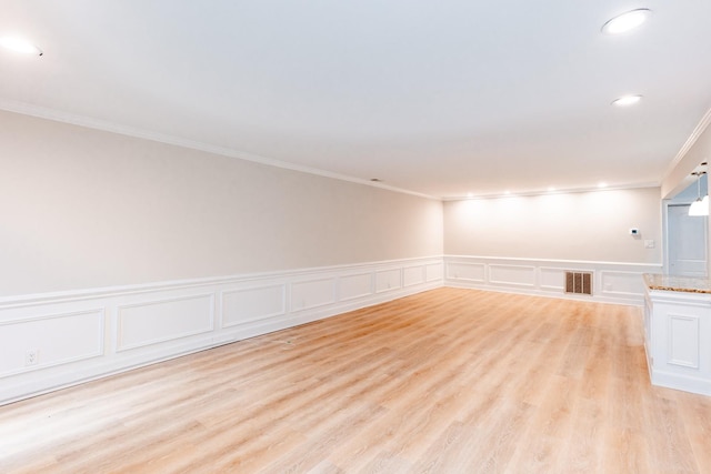 unfurnished room featuring crown molding and light wood-type flooring