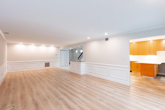 unfurnished living room featuring light hardwood / wood-style flooring and ornamental molding