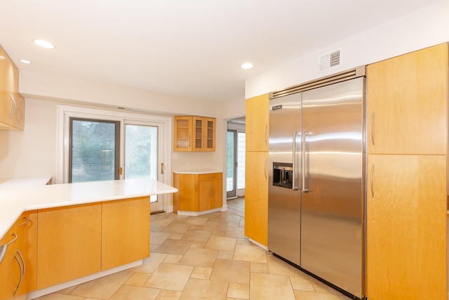 kitchen featuring kitchen peninsula, stainless steel built in fridge, and a wealth of natural light