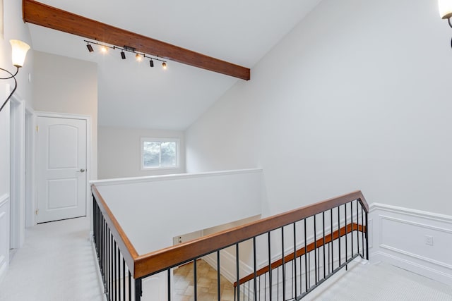 stairway featuring lofted ceiling with beams and track lighting