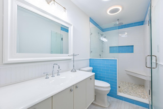 bathroom featuring tile patterned floors, vanity, a shower with shower door, and toilet