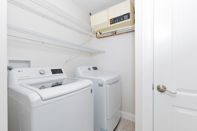 laundry room featuring light wood-type flooring and separate washer and dryer