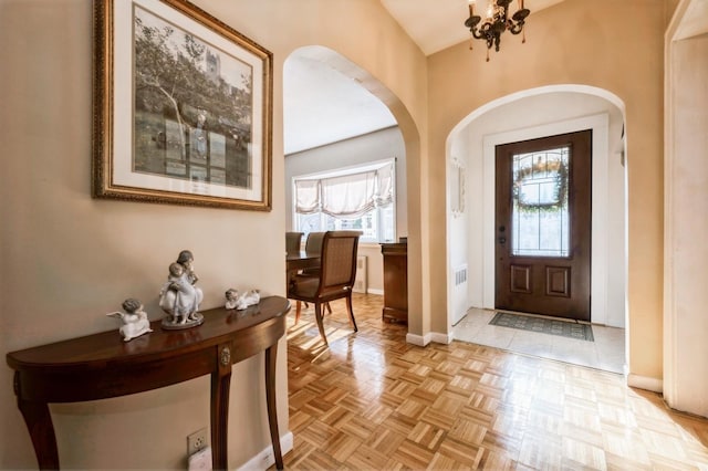 entrance foyer with an inviting chandelier and light parquet floors