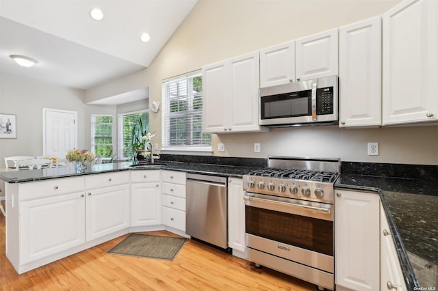 kitchen featuring dark stone countertops, white cabinetry, and stainless steel appliances