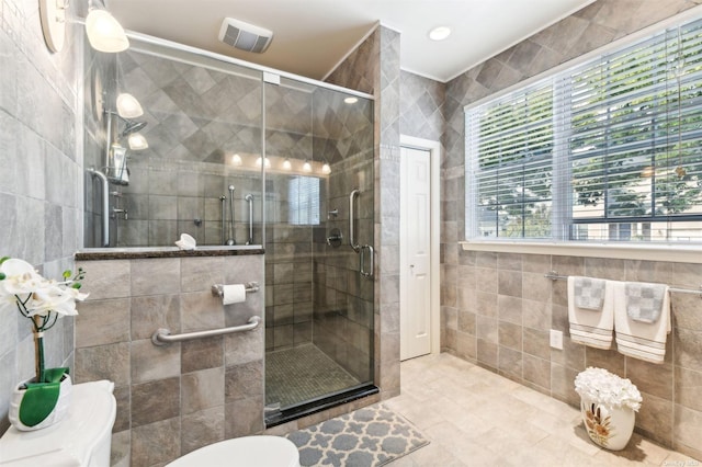 bathroom with tile patterned floors, tile walls, and walk in shower