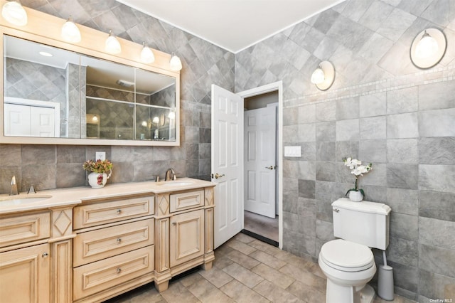 bathroom with an enclosed shower, vanity, toilet, and tile walls