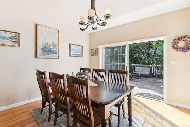 dining room with light wood-type flooring and a notable chandelier