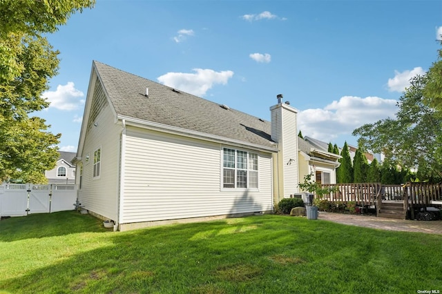 rear view of property with a lawn and a wooden deck