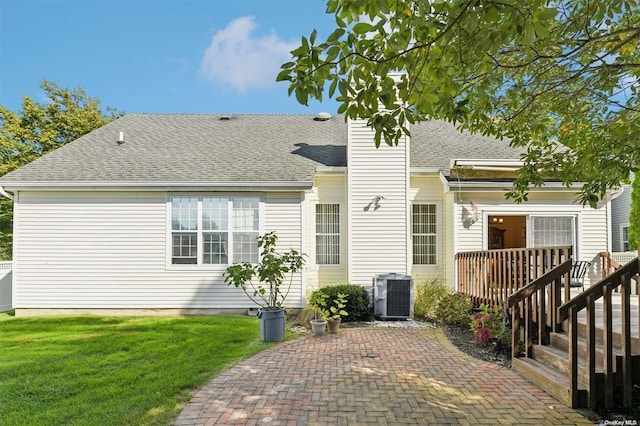 rear view of property with a patio area, a yard, cooling unit, and a deck