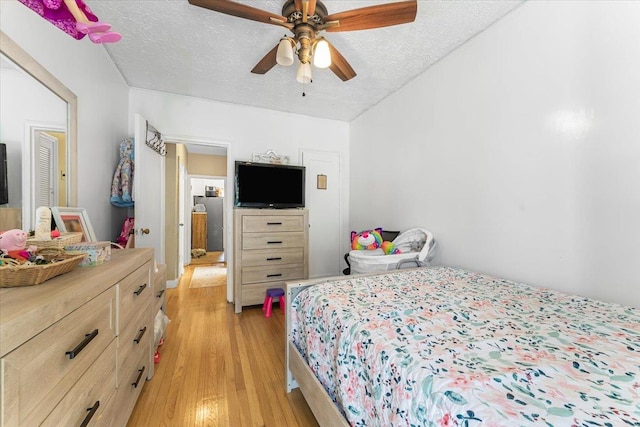 bedroom featuring a textured ceiling, light hardwood / wood-style floors, and ceiling fan