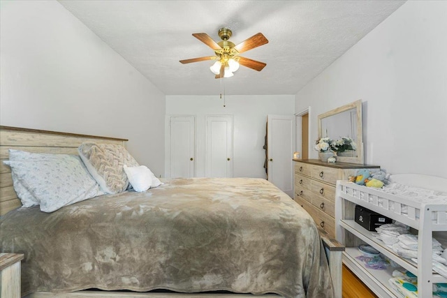 bedroom with ceiling fan, wood-type flooring, and a textured ceiling