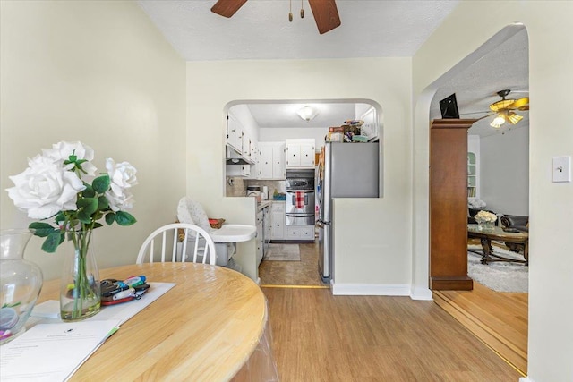 dining area featuring ceiling fan, a textured ceiling, and light hardwood / wood-style flooring