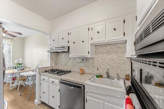 kitchen with white cabinets, sink, ceiling fan, a textured ceiling, and stainless steel appliances