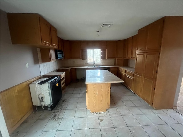 kitchen featuring sink, a center island, and tasteful backsplash