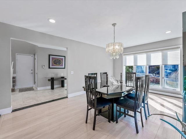 dining room with a chandelier and light wood-type flooring