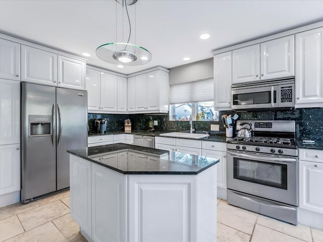 kitchen with a center island, white cabinetry, stainless steel appliances, sink, and hanging light fixtures