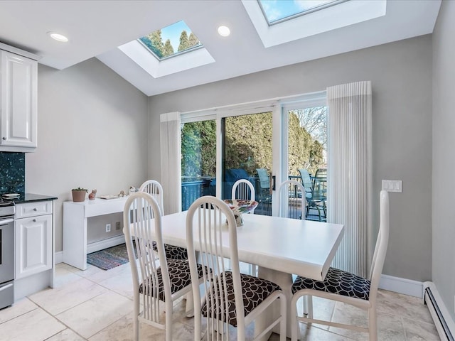 dining area with baseboard heating, lofted ceiling with skylight, and light tile patterned flooring