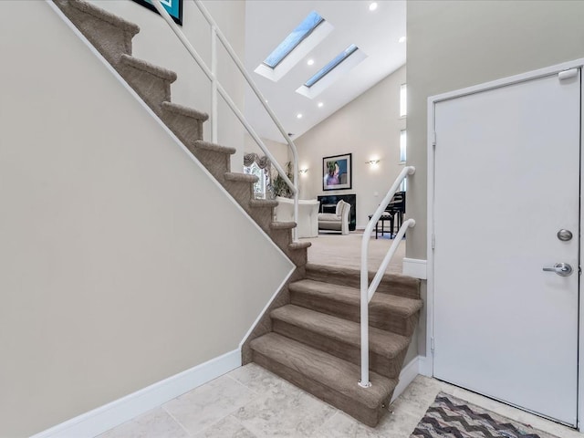 staircase with a skylight, a wealth of natural light, and a high ceiling