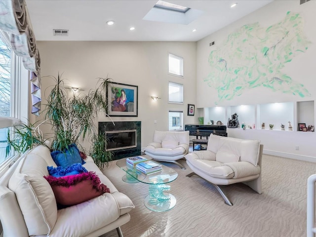 living room featuring a healthy amount of sunlight, a skylight, and a premium fireplace