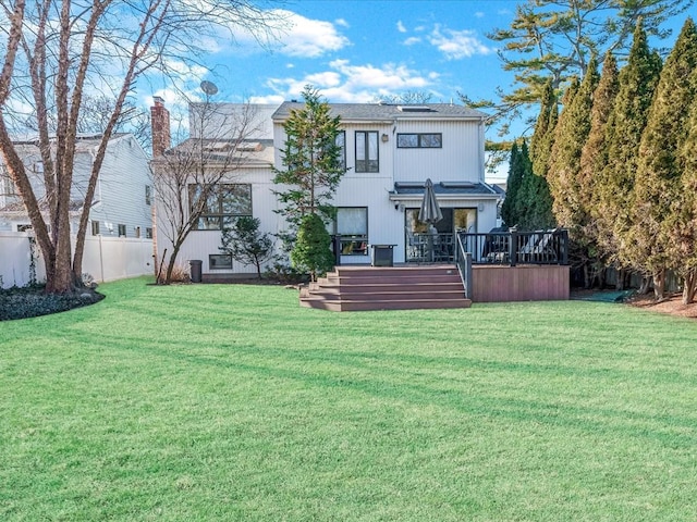 back of house featuring a lawn and a deck