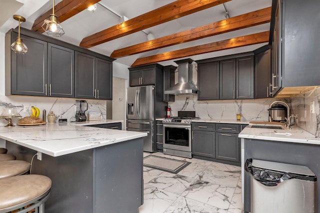 kitchen with decorative backsplash, appliances with stainless steel finishes, sink, wall chimney range hood, and decorative light fixtures