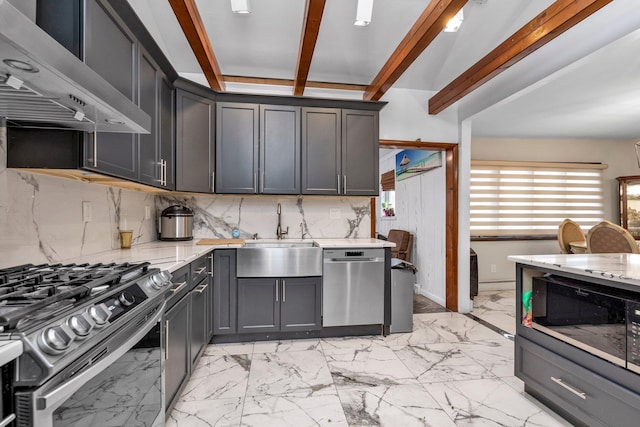 kitchen with decorative backsplash, light stone counters, wall chimney exhaust hood, stainless steel appliances, and sink