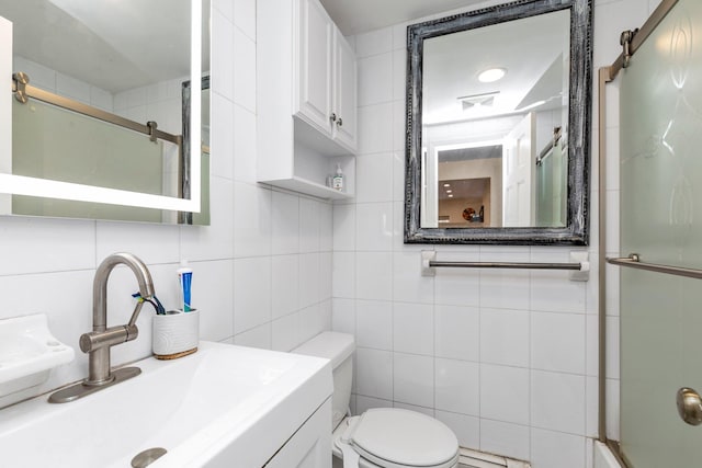 bathroom featuring vanity, toilet, tile walls, and walk in shower