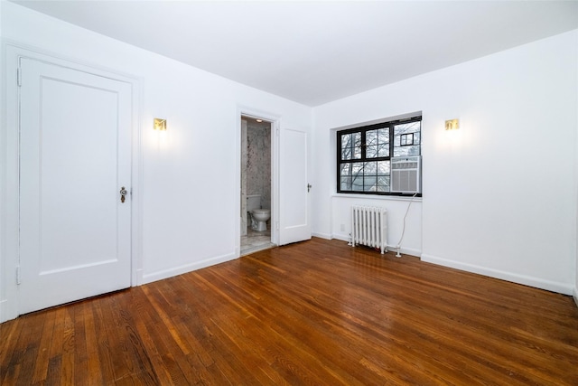 unfurnished room with radiator heating unit, baseboards, and wood finished floors