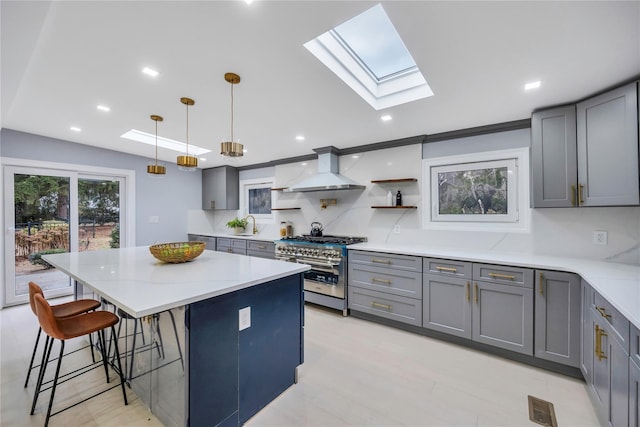 kitchen with double oven range, a center island, hanging light fixtures, tasteful backsplash, and custom range hood