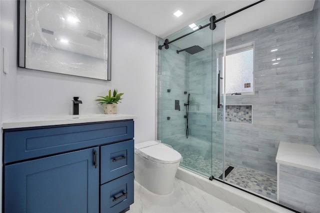 bathroom with toilet, vanity, and a shower with shower door