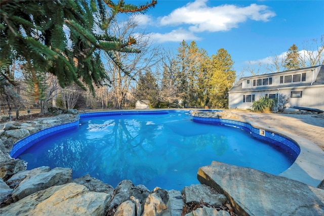 view of swimming pool featuring a patio and an in ground hot tub