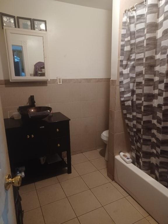 full bathroom with tile patterned flooring, tile walls, toilet, shower / bath combo, and vanity