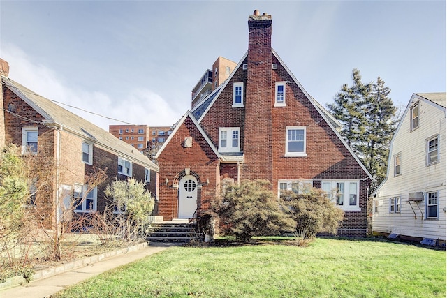 tudor-style house with an AC wall unit and a front lawn