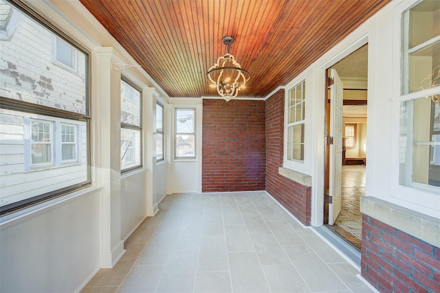 unfurnished sunroom with wooden ceiling and a chandelier