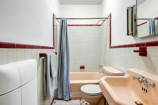 full bathroom featuring shower / tub combo, toilet, sink, and tile walls