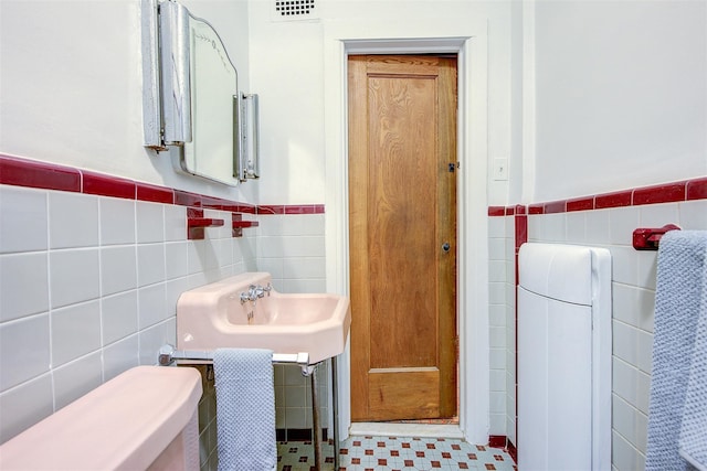 bathroom with tile walls, sink, and toilet