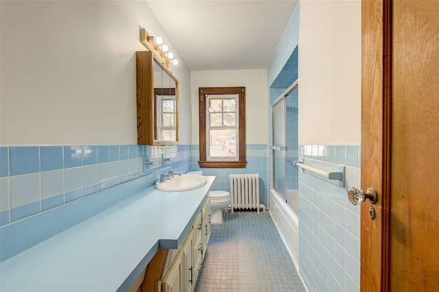 full bathroom with enclosed tub / shower combo, tile patterned flooring, radiator heating unit, vanity, and toilet