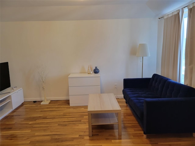 living room with light wood-type flooring and vaulted ceiling