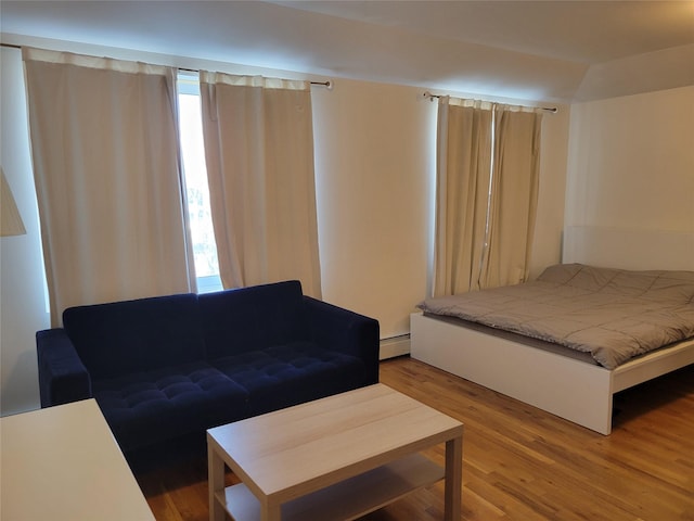 bedroom featuring hardwood / wood-style floors and baseboard heating