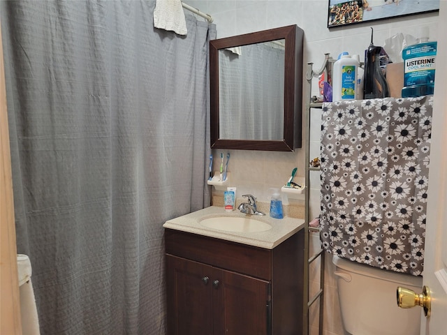 bathroom with vanity and tile walls