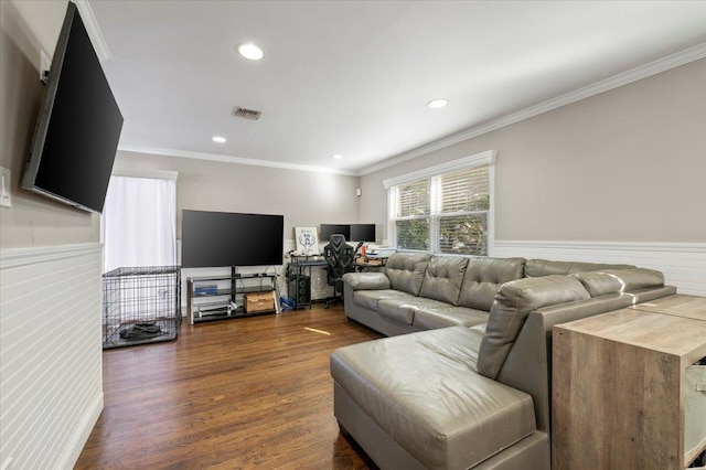 living room featuring dark wood finished floors, visible vents, wainscoting, and ornamental molding