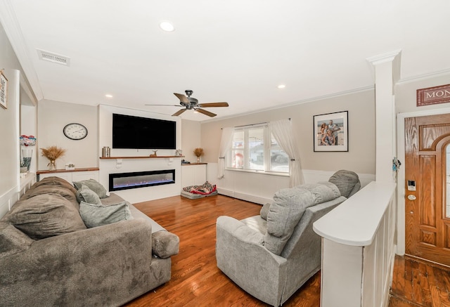 living room featuring dark wood-type flooring, ceiling fan, and ornamental molding