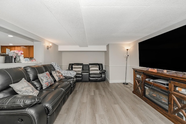 living room featuring a textured ceiling and light wood-type flooring