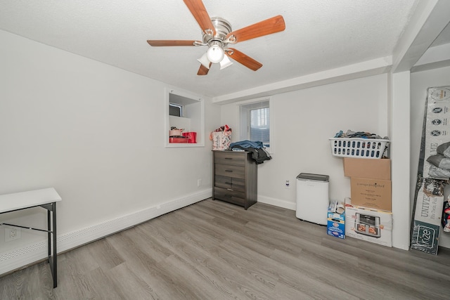 miscellaneous room with a textured ceiling, ceiling fan, light wood-type flooring, and a baseboard radiator