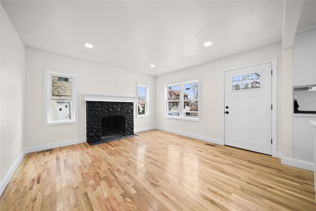 unfurnished living room featuring light wood-type flooring and a fireplace