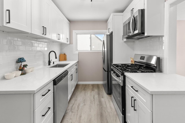 kitchen with white cabinetry, stainless steel appliances, and backsplash